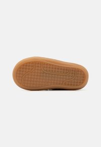 Brown rubber sole with a textured houndstooth pattern and curved sides, offering grip and flexibility. Smooth surface with rounded edges.
