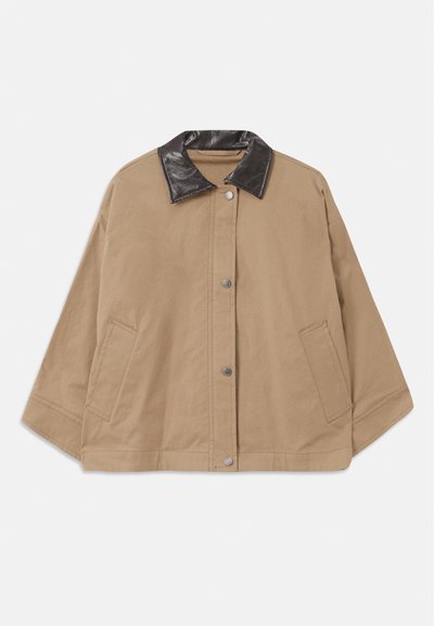 Veste en toile marron avec un col noir brillant, fermeture à boutons-pression sur le devant et deux poches latérales. Présente un design court et carré.