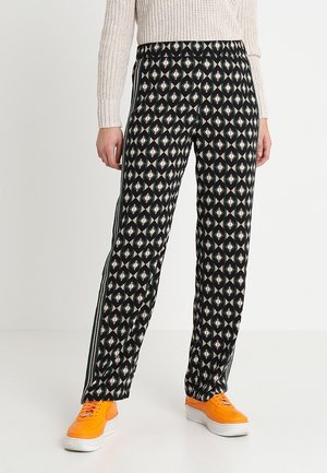 Jogging noirs à motif avec un design géométrique dans des nuances de vert, rouge et crème, présentant des bandes latérales et une taille élastique.