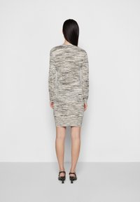 Långärmad figurnära klänning i en strukturerad ljusgrå och svart mönstring, med rund halsringning och knälång fåll.