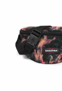 Black fanny pack with a multicolored flame-like pattern, featuring a zip closure and a black adjustable strap. Logo displayed prominently.