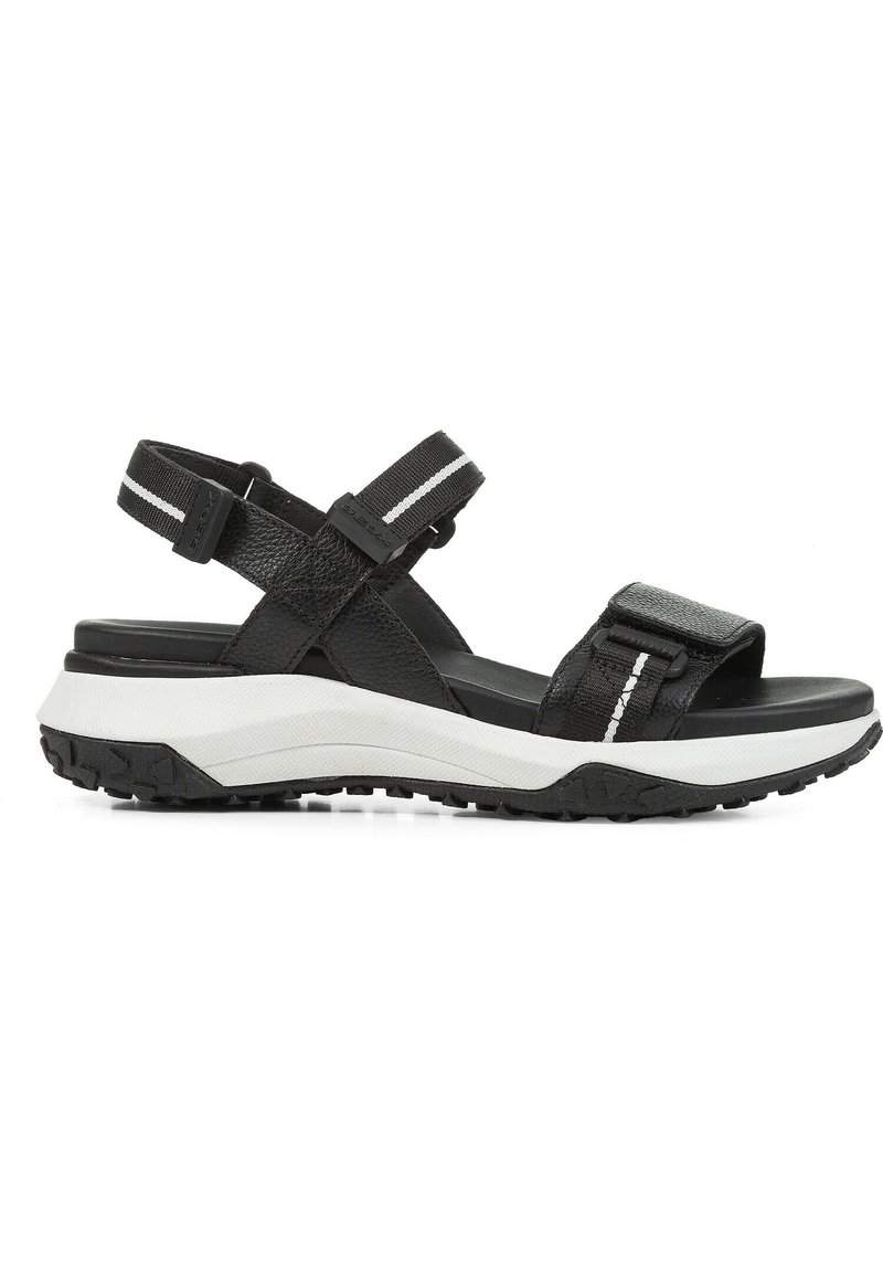 Sorte sandal med lærremmer med tekstur, justerbare lukkinger, og en hvit støtdempende såle. Gummiert svart yttersåle.