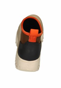 Stiefel mit einem beige-schwarzen Design und einer orangefarbenen Zuglasche. Die Außensohle ist strukturiert und bietet Grip und Stabilität.