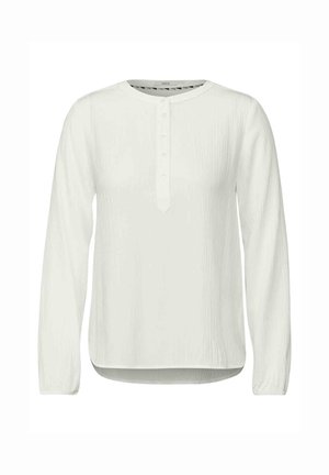 Biała koszula z długim rękawem z zaokrąglonym dekoltem, listwą z guzikami i teksturowanym materiałem. Krzywa dolna krawędź i luźny krój.