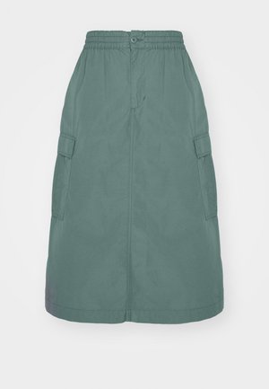 Jupe en coton vert avec une taille élastique, fermeture à boutons et poches cargo latérales. Design mi-long avec une texture lisse.