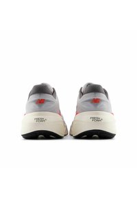 Gray running shoes with a mesh upper, red accents, Fresh Foam cushioning, and black rubber sole. Designed for comfort and performance.