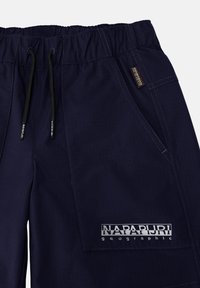 Marina blå shorts i lättviktig tyg med elastisk midja och snörning. Utrustad med en logotyp-patch och vertikala smala ränder.