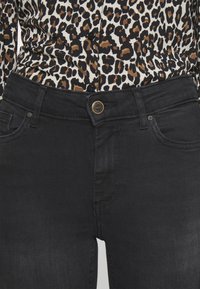 Svarta denimjeans med en klassisk passform, utrustade med knappstängning och frampocket. Tyget har en jämn textur.