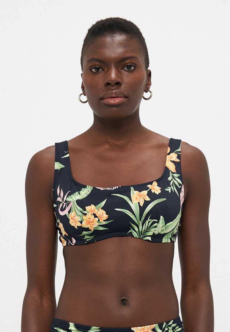 Top bikini a stampa floreale in blu scuro con scollatura quadrata e spalline larghe. Presenta brillanti motivi tropicali arancioni e verdi. Texture liscia.