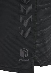 Maglietta sportiva nera in materiale testurizzato con un motivo a strisce sottili, logo Hummel e grafica a chevron in una tonalità più scura.