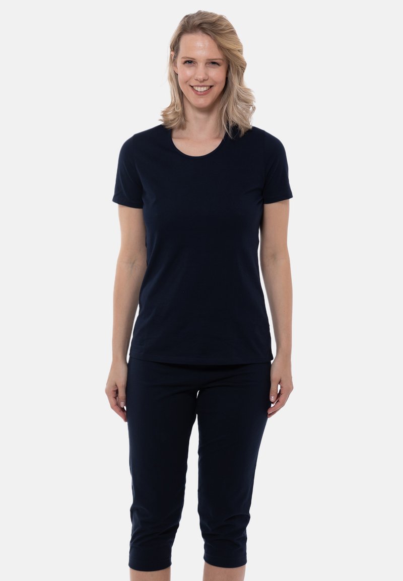 Sininen puuvillapaita pyöreällä pääntiellä ja lyhyillä hihoilla, yhdistettynä sinisiin capri-housuihin, joissa on sileä pinta ja yksinkertainen muotoilu.