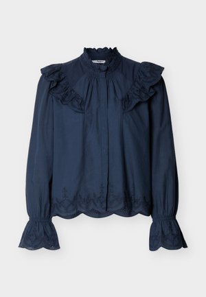 Blouse bleu marine à manches longues avec col haut volanté, bords brodés en forme d'ondulation, et épaulettes et poignets volantés.