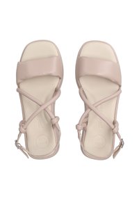 Světle růžové sandály s hladkým koženým povrchem. Mají design s křížovými popruhy, nastavitelné řemínky kolem kotníku a polstrovanou stélku označenou "SUPER SOFT."