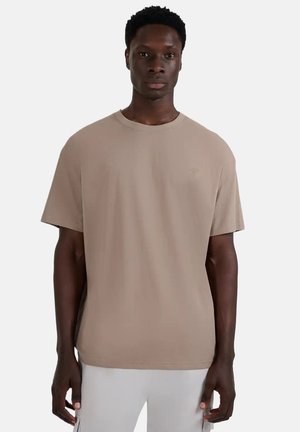 Beżowy t-shirt z krótkim rękawem o okrągłym dekolcie, wykonany z miękkiego materiału. Posiada subtelne logo na piersi oraz luźny krój.