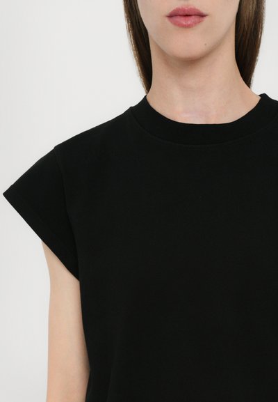 Black short-sleeve top made of soft fabric, featuring a round neck and a relaxed fit with uniquely designed, folded sleeve edges.