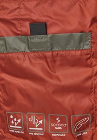 Czerwona tkanina odporna na wodę i wiatr o lekkiej, gładkiej teksturze. Zawiera ikony informujące o cechach: zrównoważony rozwój, ultra-lekka konstrukcja.