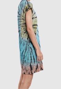 Sukienka w stylu tie-dye łączy odcienie niebieskiego, zielonego i różowego, ma luźny krój, krótkie rękawy i okrągły dekolt.