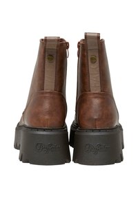 Brązowe botki za kostkę z faux skóry, z masywną czarną podeszwą, zamkiem błyskawicznym i wytłoczonym logo na tylnej części.