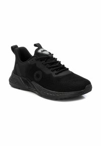 Zapatillas deportivas negras de malla con un acabado texturizado, punta redonda, suela acolchada y un logo en la lengua y en el costado.