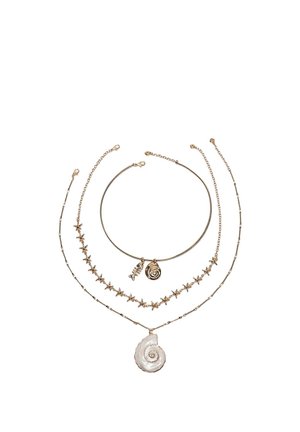 Trzy naszyjniki w złotym odcieniu: obroża związaną ze spiralną muszlą i zawieszką, średniej długości z rozgwiazdą oraz długi z dużym białym zawieszką w kształcie spiralnej muszli.