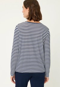Marineblaue und weiße gestreifte Langarmshirt mit Rundhalsausschnitt. Weicher Stoff, entspannte Passform und leicht abgerundeter Saum hinten.
