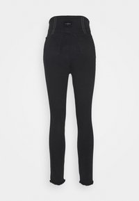 Jeans de mezclilla negros de tiro alto con un ajuste slim, dobladillo desgastado y costuras en contraste. Presenta dos bolsillos traseros y una etiqueta de la marca en la cinturilla.