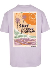Lila lyhythihainen t-paita, jossa on graafinen printti, jossa on aaltoja, palmuja, aurinko ja teksti "SURF CLUB CALIFORNIA."