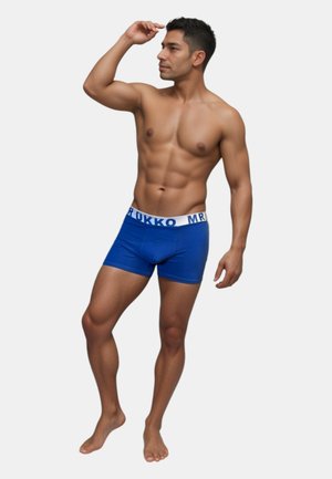 Blaue Baumwoll-Boxershorts mit einem weißen Bund, auf dem der Text "MR RUKKO" steht, getragen von einer männlichen Figur, die barfuß steht.