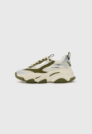 Tömb sneaker fehér és olíva zöld színben. Hálós anyag ezüst díszítésekkel, vastag talppal, és húzófüllel a sarkán a könnyű felhúzás érdekében.