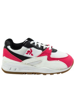 Zapatilla deportiva blanca, rosa y negra con cordones blancos, logo en el lateral y suela de caucho, mostrada desde el lado exterior.