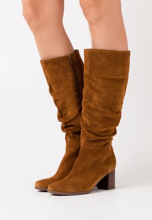 Weiche, knielange Stiefel aus Veloursleder in einem warmen Braunton mit einem lässigen Design, ausgestattet mit einem seitlichen Reißverschluss und einem stabilen Blockabsatz.