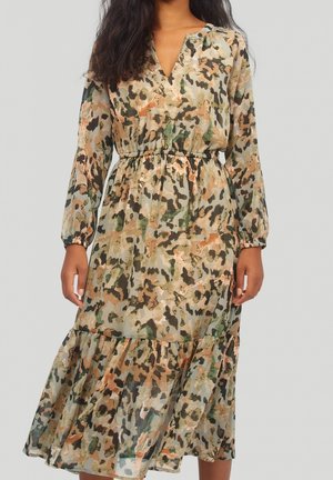 Long, sheer dress featuring a green, brown, and peach camouflage pattern, with a v-neck, elastic waist, and tiered ruffle hem.