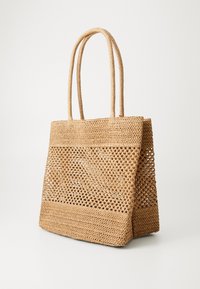 Natürliche Strohtasche mit zwei strukturierten Griffen, offenem Webmuster und solidem Boden, in einem hellbeigen Farbton.