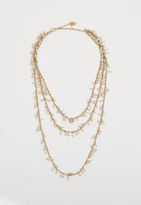 Gouden gelaagde ketting met drie kettingen en delicate clusters van kleine witte kralen, evenals een centraal decoratief hangertje.
