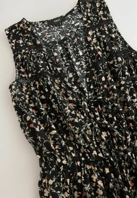 Robe noire à motifs floraux avec un design sans manches, taille froncée et des détails en dentelle délicats avec de petits motifs de fleurs roses et blanches.