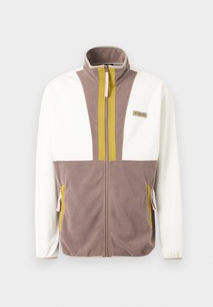 Jachetă fleece cu mâneci albe, corp taupe, dungi verticale olive lângă fermoar, buzunare cu fermoar și patch cu brandul Columbia pe piept.