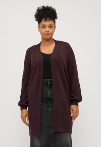 Cardigan bordeaux realizzato in un morbido materiale a maglia, con scollatura a V, apertura frontale e maniche lunghe leggermente gonfiate.