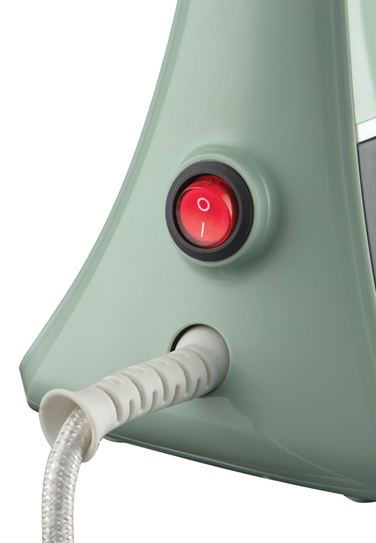 Plancha de vapor de plástico verde menta con un botón de encendido rojo redondo, un cordón de alimentación texturizado blanco y un diseño suave y curvado.