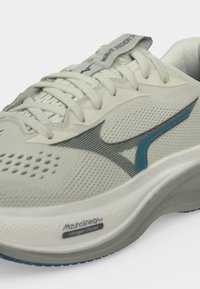 Ανοιχτό γκρι παπούτσι τρεξίματος Mizuno Wave Rider με μπλε λογότυπο, επενδυμένο λαιμό, κλείσιμο με κορδόνια και λεπτομέρεια στη μεσαία σόλα με αζωτούχο έγχυση MizunoEnerzy.
