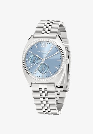 Sølv rustfrit stål ur med en blå urskive, der har en tekstureret overflade og to mindre urskiver. Remmen er i metal link stil.