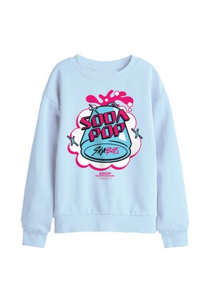 Light blue sweatshirt with a colorful graphic of a soda can splashing and text "Soda Pop" and "Kpop Demon Hunters" on the front.