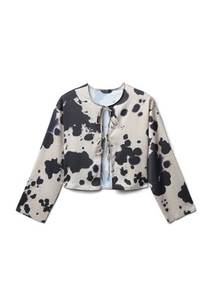 Blouse cropped à manches longues avec un motif éclaboussé abstrait noir et beige, dotée de deux liens à l'avant au niveau du cou et de la poitrine.