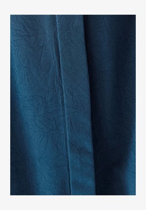 Kankaita syvissä sinisessä, jossa on ryppyinen ulkonäkö. Materiaali esittää hienoja kuvioita ja laskeutuu sujuvasti.