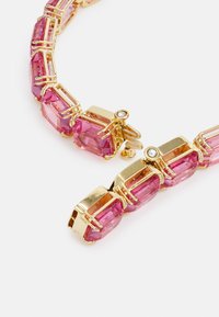 Gold-tone necklace featuring large pink angular gemstones, interconnected with metallic clasps, and a small clear accent stone.