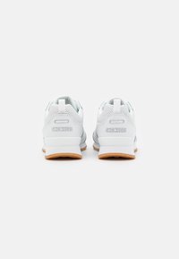 Weiße Skechers-Sneaker mit einem strukturierten Mesh-Obermaterial, gepolstertem Schaftrand und hellblauen Akzenten. Gummiaußensohle für besseren Halt.