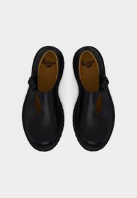 Ζευγάρι μαύρα δερμάτινα παπούτσια Dr. Martens Mary Jane με λουράκια με αγκράφα, στρογγυλεμένες μύτες και επενδεδυμένες εσωτερικές σόλες, εμφανιζόμενα από πάνω.