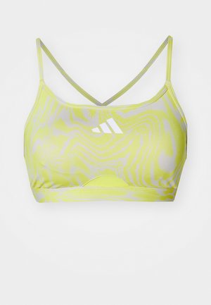 Neon-gelbes Sport-BH mit Wellenmuster, dünnen, überkreuzten Trägern und einem Logodesign in Weiß auf der Vorderseite. Glatte Stoffstruktur.