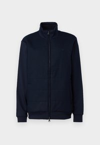 Navy sininen vetoketjullinen takki, jossa on korkea kaulus, vuorattu etuosa, ribbaatut hihansuut ja sileä pinnan rakenne. Yksinkertainen muotoilu ilman näkyviä kuvioita tai koristeita.