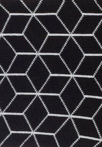 Schwarzer Stoff mit einem geometrischen Muster aus weißen Sechsecken und Rauten, mit kontrastierenden Umrissen und einer strukturierten Oberfläche.