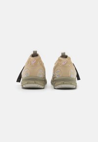 Béžové sportovní boty z síťoviny a syntetického materiálu, s texturovanou podrážkou a růžovým logem na patě. S pull taby.